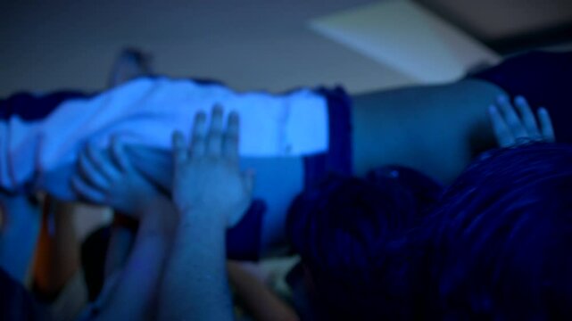 A group of people hold a girl above their heads  while dancing in a mosh pit at a wild house party