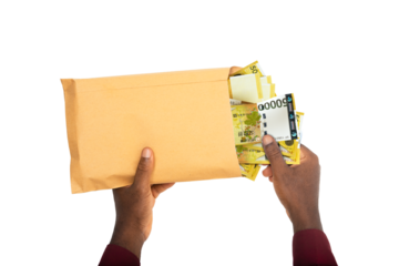 black male hands holding opened brown envelope containing South korean won notes on white background
