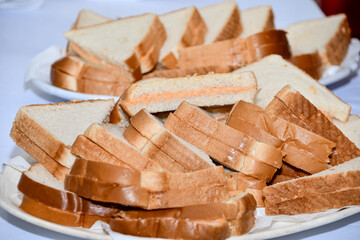 Pile of halved sandwiches, filled with yellow cheese