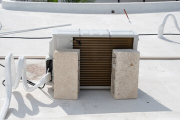 Air conditioner compressors attached to bricks to protect them from the arrival of a hurricane.