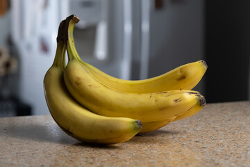 Yellow Bananas in a Bunch on Brown Granite Counter