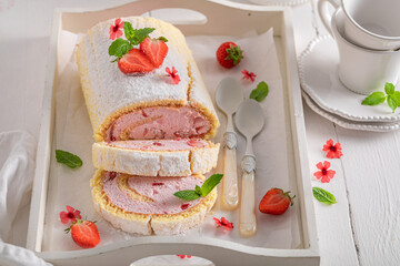 Delicious and creamy strawberry roulade as fresh summer cake.