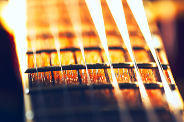 Neck of a guitar with a close up of the strings. Macro image of guitar strings showing intricate...