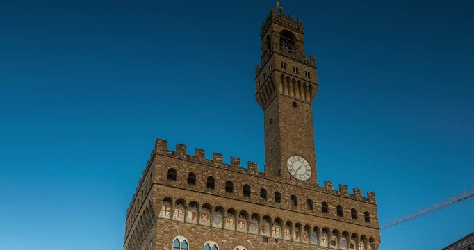 Florence, Italy - May 31, 2024: Piazza della Signoria. Time-lapse, zoom-out transition. Walking people on the foreground. Clear sky.
