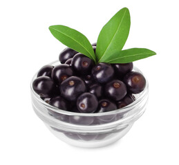 Fresh ripe acai berries in glass bowl and green leaves isolated on white