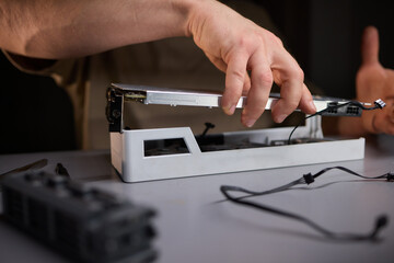 A technician is skillfully repairing a computer GPU fan with precision tools in a workshop