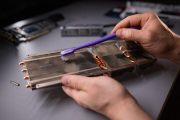 A technician is skillfully repairing a computer GPU fan with precision tools in a workshop