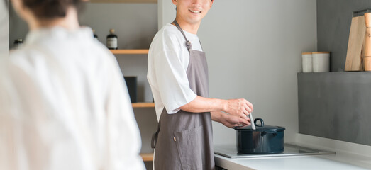 キッチンで料理・家事をする若いアジア人夫婦・カップル（自炊・共働き・ディンクス・趣味）  © buritora