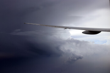 Aerial View of Urban Landscape with Airplane Wing Under Clear Blue Sky and Scattered Clouds