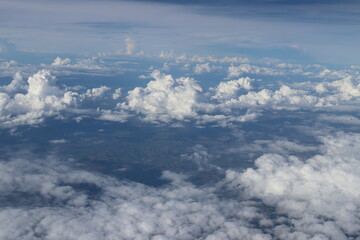 Aerial View of Urban Landscape with Airplane Wing Under Clear Blue Sky and Scattered Clouds