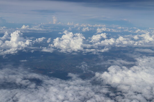 Aerial View of Urban Landscape with Airplane Wing Under Clear Blue Sky and Scattered Clouds