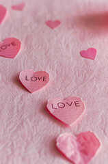 Fototapeta premium A pink paper in shape of hearts with the word 