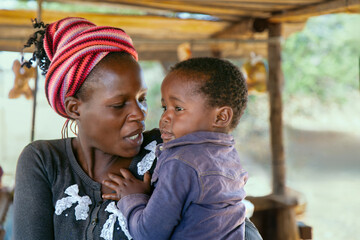 village african mother and child portrait , poverty shack background