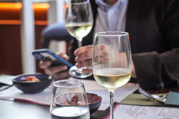 Business Lunch: Man Checking Cell Phone with Glass of Wine
