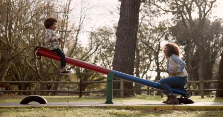 Park, mother and child on seesaw for playing, riding and bonding together on holiday weekend. Nature, playground equipment and entertainment of happy family, mom and son with balance for fun outdoor - Powered by Adobe