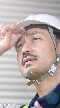 Workers at a construction site Men sweating in work clothes Please be safe and prevent heat stroke in summer Vertical video Slow