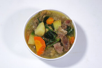 boiled meat vegetable soup served in a porcelain bowl