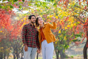 happy young caucasian couple hands holding each other walking in autumn park,concept of people lifestyle,love,family,relationship,travel