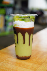 Avocado juice Smoothie in a glass served with sweet chocolate condensed milk