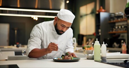 Man, chef and serious with food in kitchen at restaurant for fine dining, meal and creativity. Male employee, professional and cooker with pride for culinarily, hospitality and catering service - Powered by Adobe