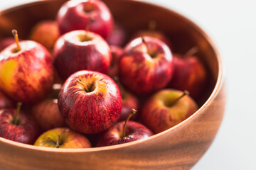 plenty of red apples in big wooden fruit bowl on kitchen countertop