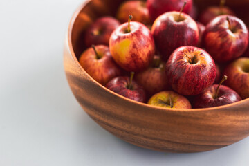 plenty of red apples in big wooden fruit bowl on kitchen countertop