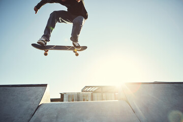 Skateboard, man legs and jump in urban skate park with trick and training in Los Angeles with mockup. Sunshine, deck and skater in city with balance, skating competition and fun board flip by ramp © ReeseArcurs/peopleimages.com