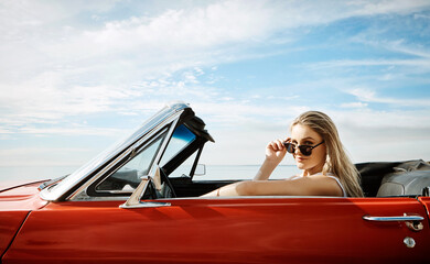 Woman, sunglasses and driving convertible for road trip, adventure and freedom with holiday or...