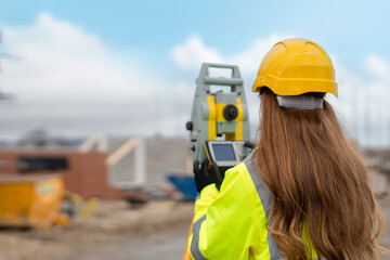Female Construction Worker Using Surveying Equipment at a Building Site