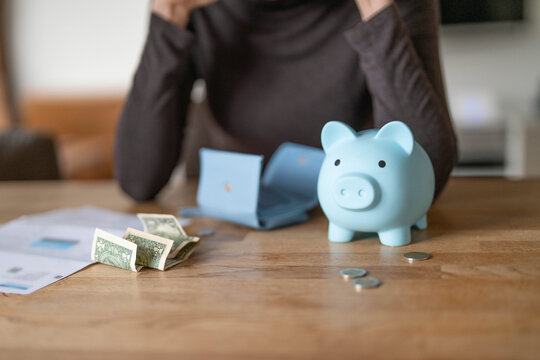 Close Up of Blue Piggy Bank on Table With Cash and Coins