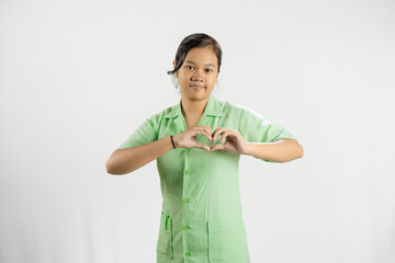 Young Asian female nurse making love shapes with her hands, gesture of love, dedicated work, concept of health care, isolated white background.
