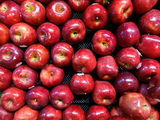 Vibrant red apples neatly arranged on a supermarket shelf. Crisp and fresh, these apples are a perfect symbol of health and natural goodness. Ideal for illustrating food, health, or market concepts.