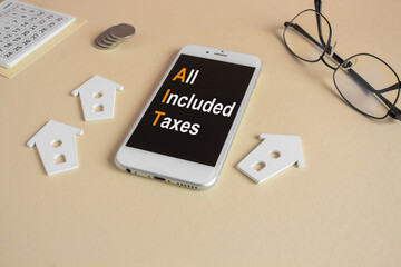 Concept words AIT All included taxes written on the mobile phone screen. Beautiful beige background. Glasses, miniature houses, coins. Business concept.