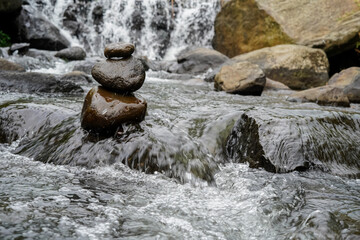 A Closeup of stacked rocks, Stack of zen stones in the background of a flowing river
