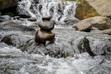 A Closeup of stacked rocks, Stack of zen stones in the background of a flowing river