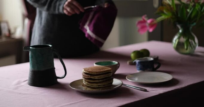 Tasty pancake breakfast with jam and apple. Tea served on a kitchen table. Simple life or perfect morning concept