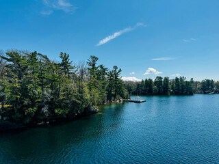 Forest and Lake Ontario with Wooden Dock Under a Clear Blue Sky in Kingston, Ontario, Canada