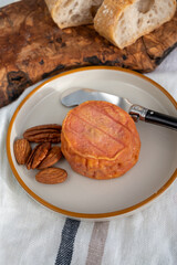 Rond des Vignes washed-rind cheese with.ivory-orange rind, strong nose with aromas, French soft cheese with orange rind