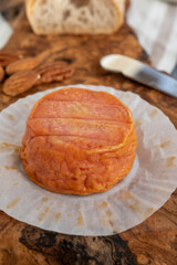 Rond des Vignes washed-rind cheese with.ivory-orange rind, strong nose with aromas, French soft cheese with orange rind