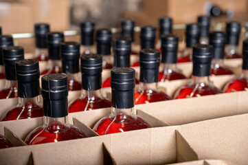 Storage of bottles of cognac spirit aged in French oak barrels in shop in distillery house, Cognac...