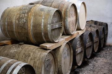 Aging process of cognac spirit in old dark French oak barrels in cellar in distillery house, Cognac white wine region, Charente, Segonzac, Grand Champagne, France