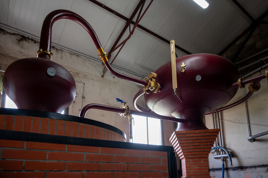 Double distillation process of cognac spirit in Charentias copper alambic still pots and boilers in old distillery in Cognac white wine region, Charente, Segonzac, Grand Champagne, France