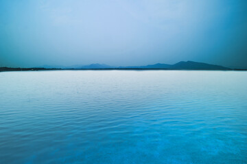 Only blue color tone of sky, water, and mountains there is nothing.