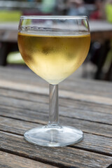 Tasting of Bordeaux white wine in Sauternes, left bank of Gironde Estuary, France. Glasses of white sweet French wine served in outdoor restaurant