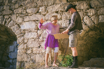 Arab mercenary speaks to the Archaeologist against the backdrop of an ancient fortress. Historical reconstruction of archaeological research of the 19th century. School project. Historical excursion