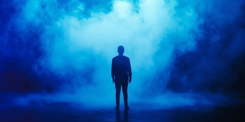 Fototapeta premium Silhouette of person in thick blue smoke creating mysterious atmosphere, mystery concept