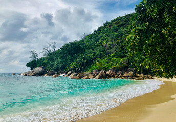 Fototapeta premium Idyllic beach with turquoise water and lush greenery on Praslin Island, Seychelles