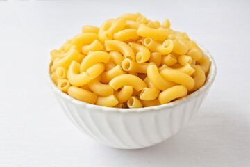 Raw uncooked macaroni in a white bowl on a white background