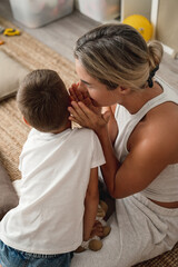 Fototapeta premium Happy Mother and her Little Son Sharing Secrets at Home