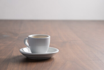 Fresh espresso in a white cup on walnut table with copy space